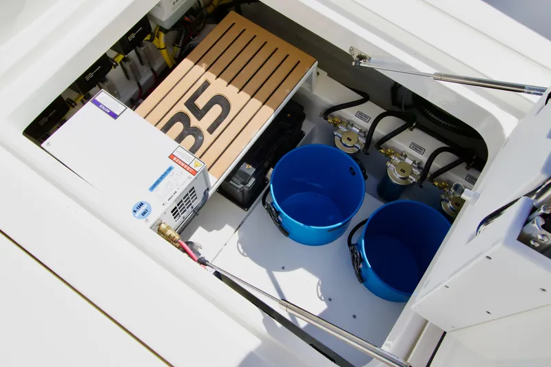Slide: The Image of 2025 Regulator 35 boat storage compartment with equipment and blue buckets. - 13