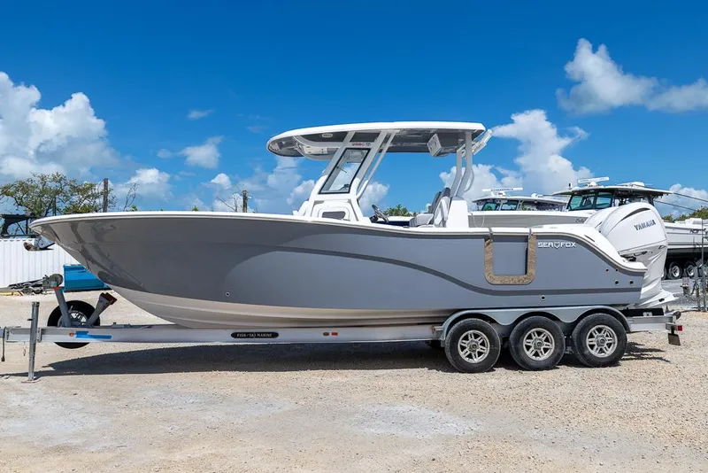 Slide: The Image of 2026 Sea Fox 288 Commander boat on trailer under clear blue sky. - 1