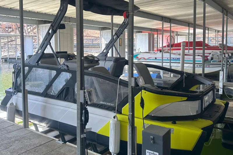 Slide: The Image of 2022 Sea-Doo Switch Cruise 18 docked in a covered marina. - 2