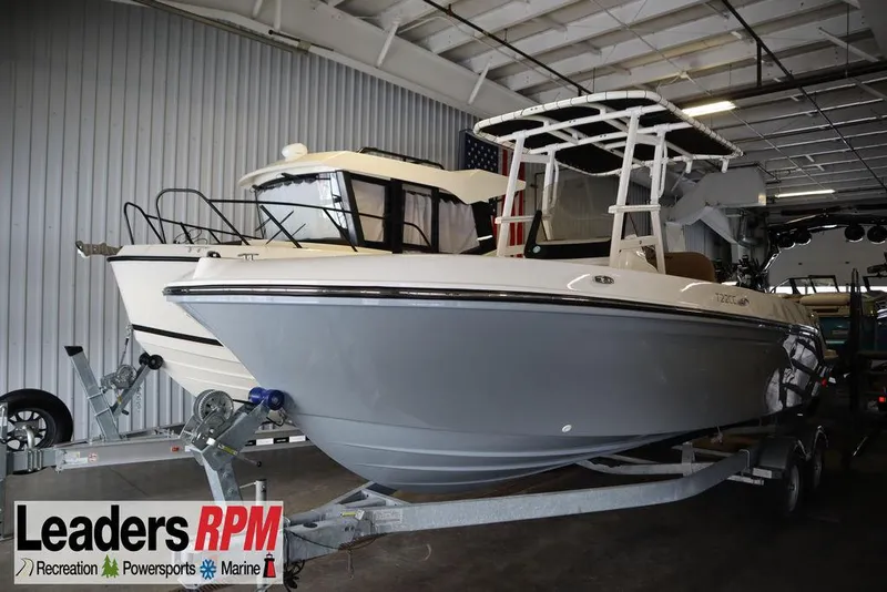 The Image of 2025 Bayliner 22 CC Trophy boat on trailer in indoor showroom. - 1