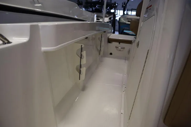 Slide: The Image of 2025 Bayliner 22 CC Trophy boat interior with sleek white cabinetry and storage compartments. - 11