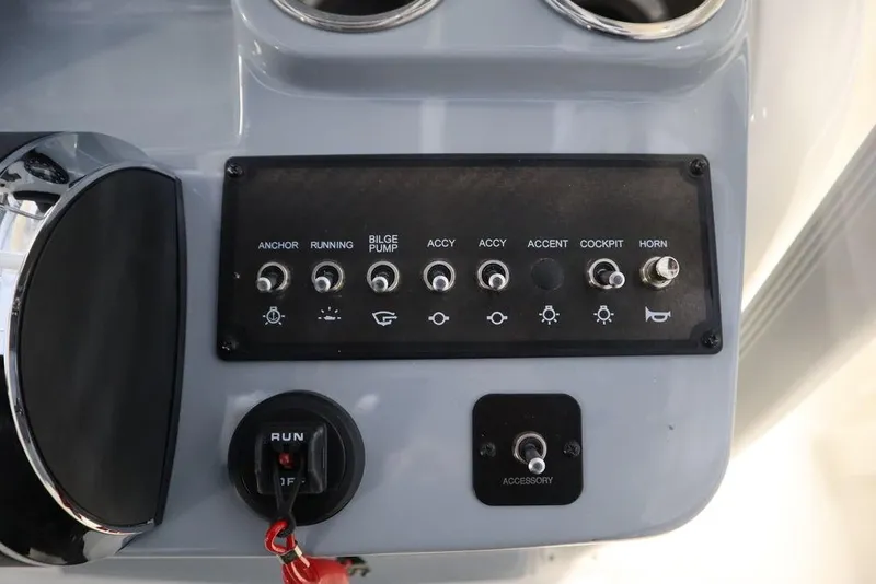 Slide: The Image of Control panel of 2025 Bayliner 22 CC Trophy boat with various switches and ignition. - 18