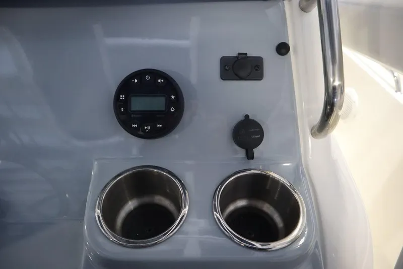 Slide: The Image of Control panel and cup holders on 2025 Bayliner 22 CC Trophy boat. - 19