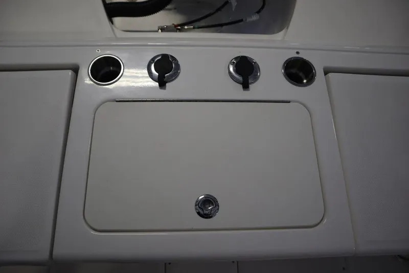 Slide: The Image of 2025 Bayliner 22 CC TROPHY boat dashboard with control knobs and storage compartment. - 29