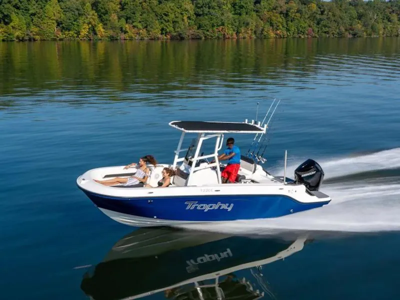 Slide: The Image of 2025 Bayliner 22 CC Trophy boat cruising on a calm lake with passengers. - 32