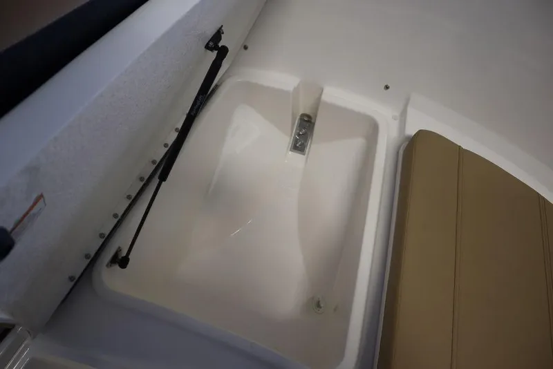 Slide: The Image of 2025 Bayliner 22 CC TROPHY boat interior storage compartment with cushioned seating. - 4