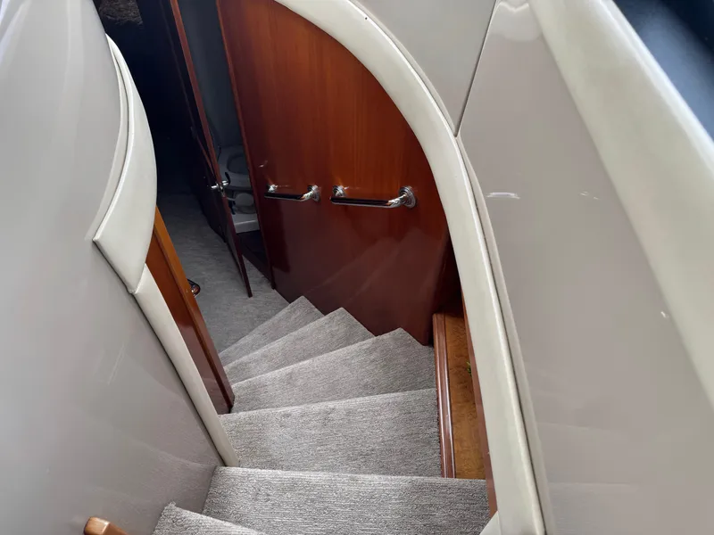 Slide: The Image of Staircase inside 2005 Carver 560 Voyager yacht with carpeted steps and wooden handrails. - 21