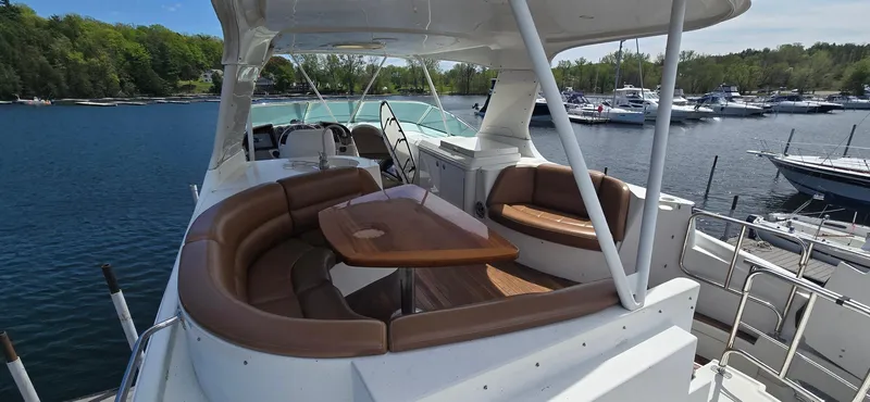 Slide: The Image of 2005 Carver 560 Voyager yacht with spacious seating and table on deck, docked at marina. - 33