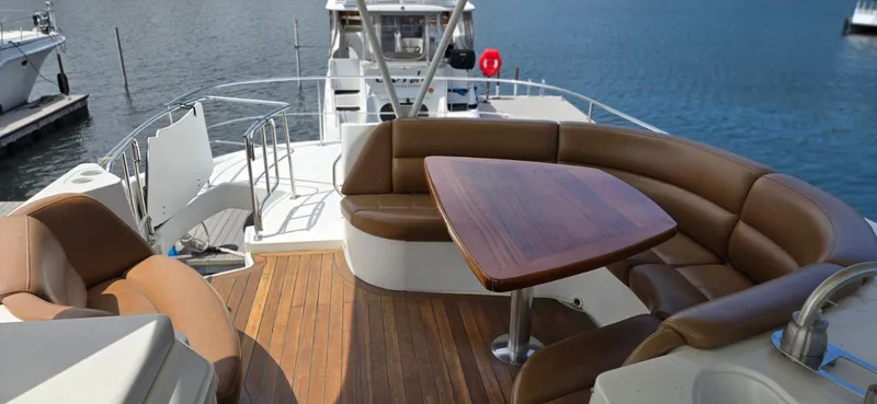 Slide: The Image of 2005 Carver 560 Voyager yacht with spacious deck, brown seating, and wooden table. - 34