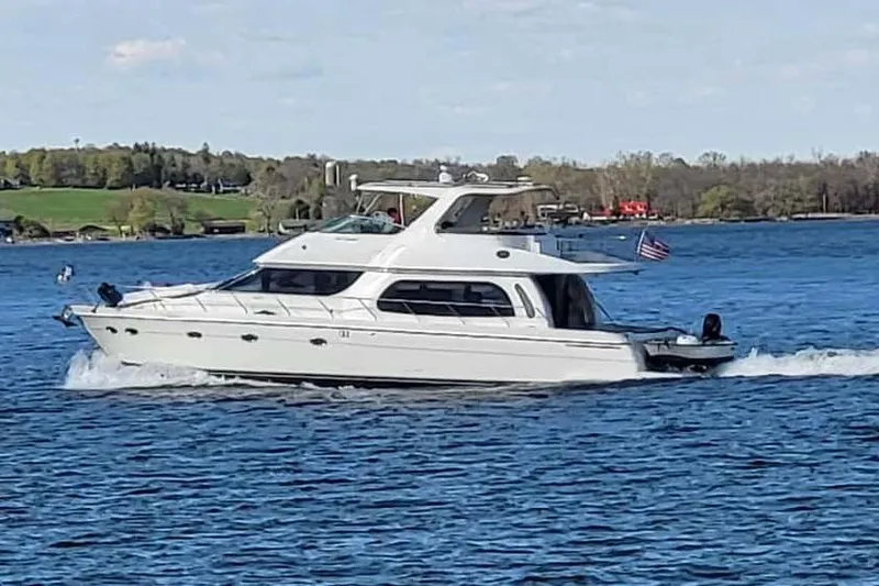 The Image of 2005 Carver 560 Voyager yacht cruising on a scenic lake. - 0