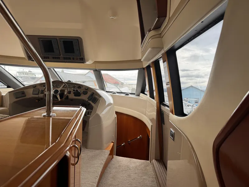 Slide: The Image of Interior of 2005 Carver 560 Voyager yacht, featuring helm and panoramic windows. - 12