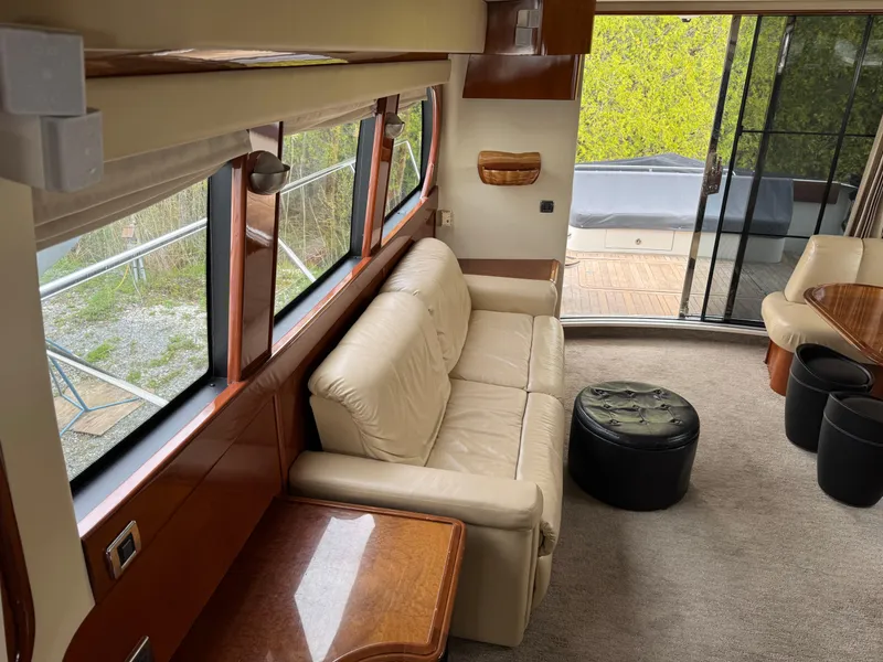 Slide: The Image of Interior of 2005 Carver 560 Voyager yacht with beige sofa and large windows. - 18