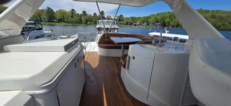 Slide: The Image of 2005 Carver 560 Voyager yacht deck with seating, table, and scenic lake view. - 35