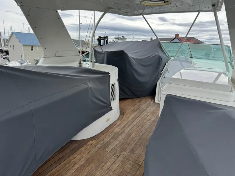 Slide: The Image of 2005 Carver 560 Voyager yacht deck with covered seating and wooden flooring. - 36