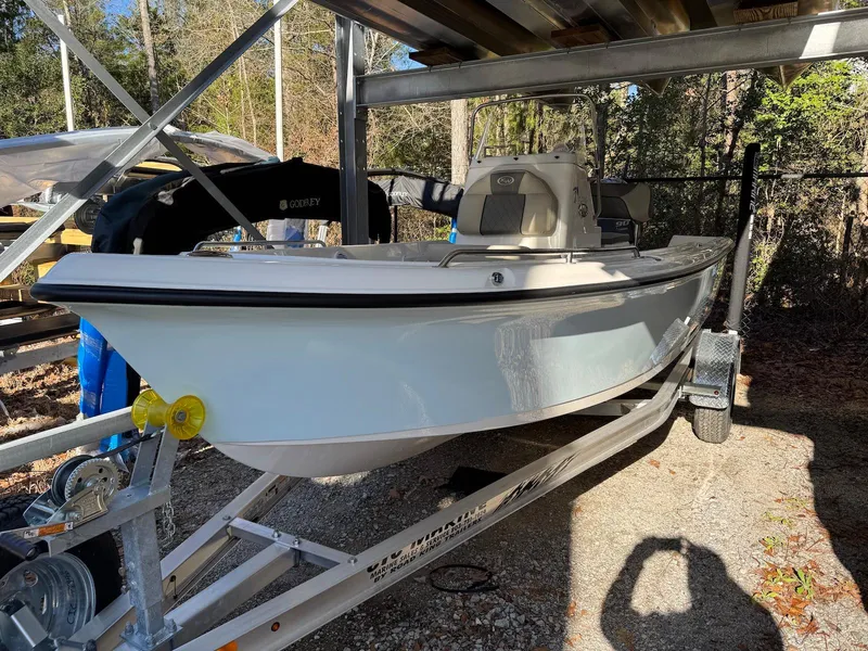 Slide: The Image of 2025 Key West 1720 Center Console boat on a trailer, under a metal shelter. - 3