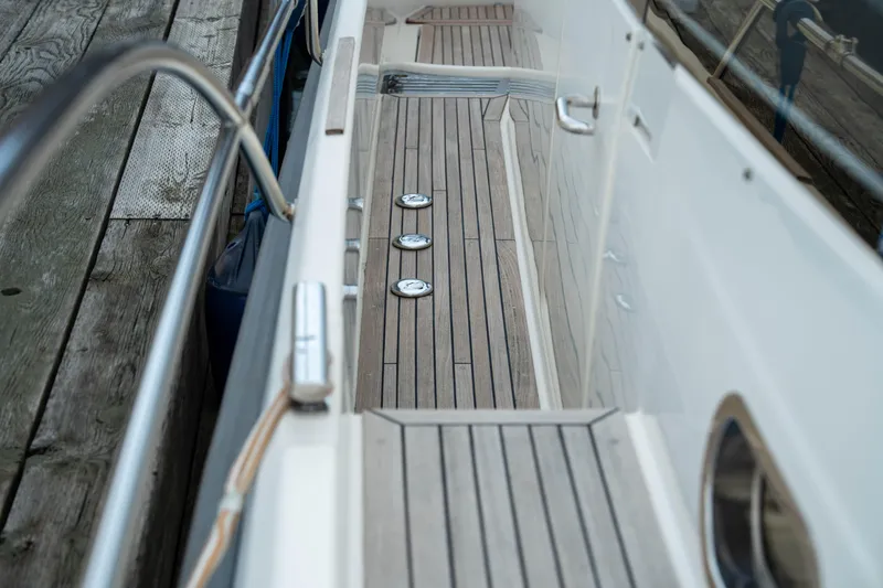 Slide: The Image of 2017 Nimbus 365 Coupe boat deck with wooden flooring and metal fixtures. - 14