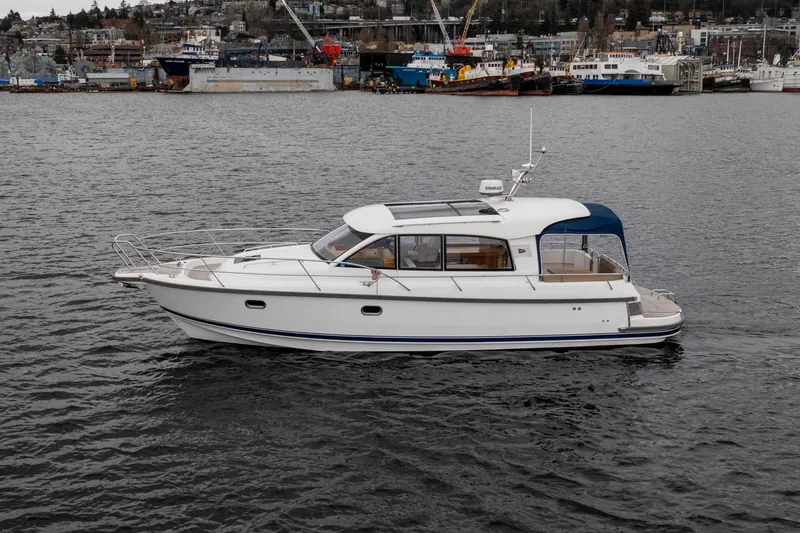 Slide: The Image of Nimbus 365 Coupe 2017 cruising on a calm body of water near a busy harbor. - 2