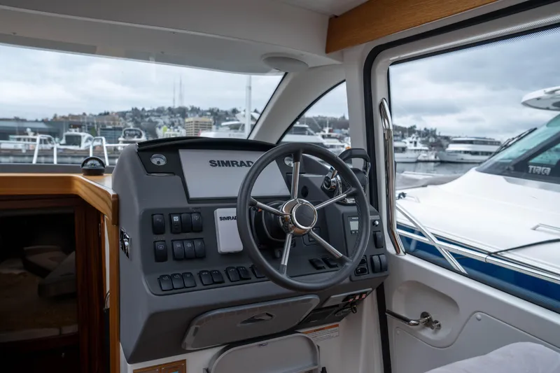 Slide: The Image of Steering wheel and control panel of 2017 Nimbus 365 Coupe boat, docked in marina. - 21