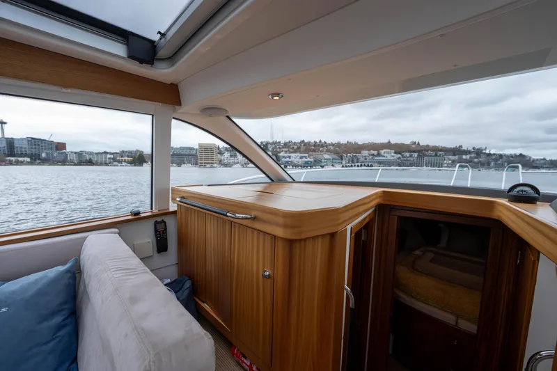 Slide: The Image of Interior of 2017 Nimbus 365 Coupe boat with wooden cabinetry and waterfront view. - 28