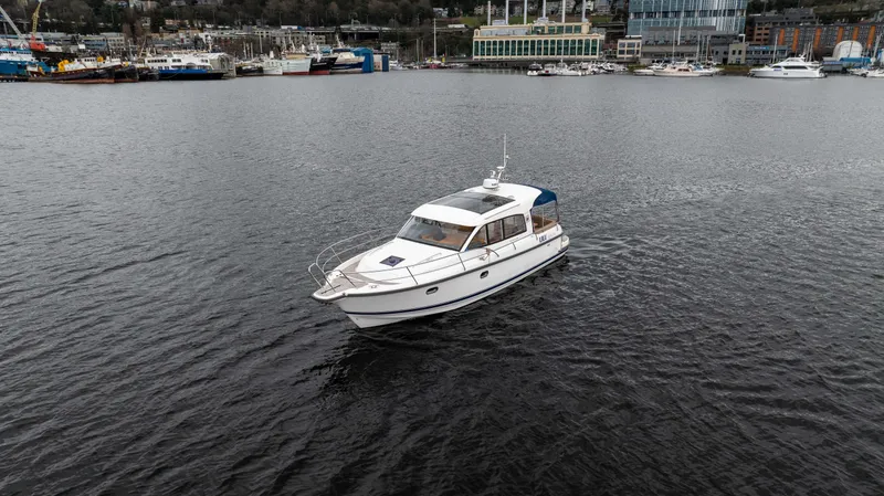 Slide: The Image of Nimbus 365 Coupe 2017 cruising on a calm harbor with boats in the background. - 3