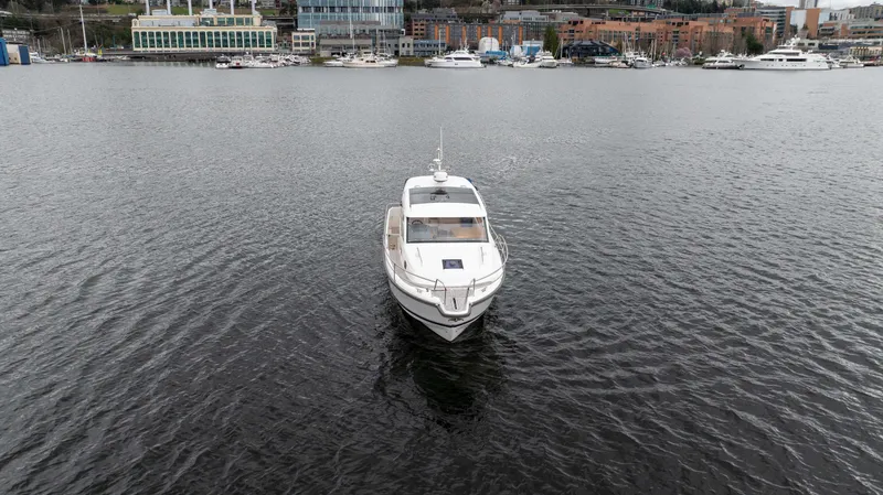 Slide: The Image of Nimbus 365 Coupe 2017 boat on calm water near marina, cityscape in background. - 4