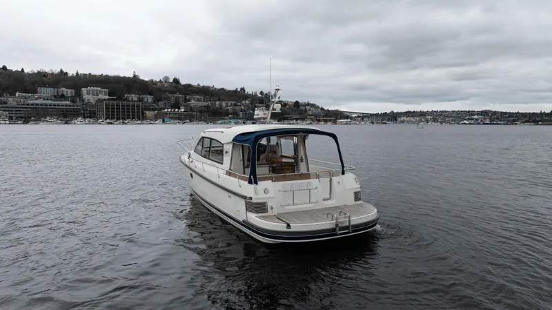 Slide: The Image of Nimbus 365 Coupe 2017 boat on a calm lake under cloudy skies. - 6