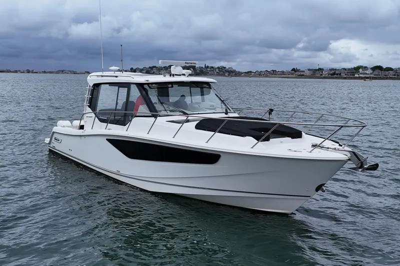 Slide: The Image of 2021 Boston Whaler 405 Conquest boat on calm water under cloudy skies. - 2