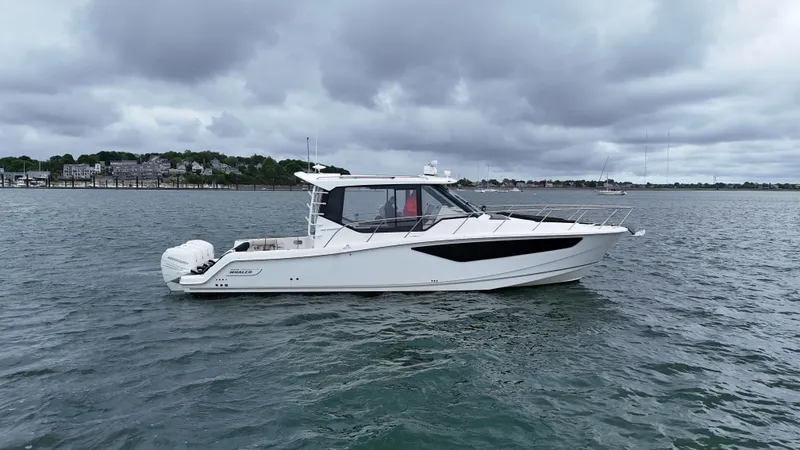 Slide: The Image of 2021 Boston Whaler 405 Conquest boat on calm water under cloudy skies. - 5