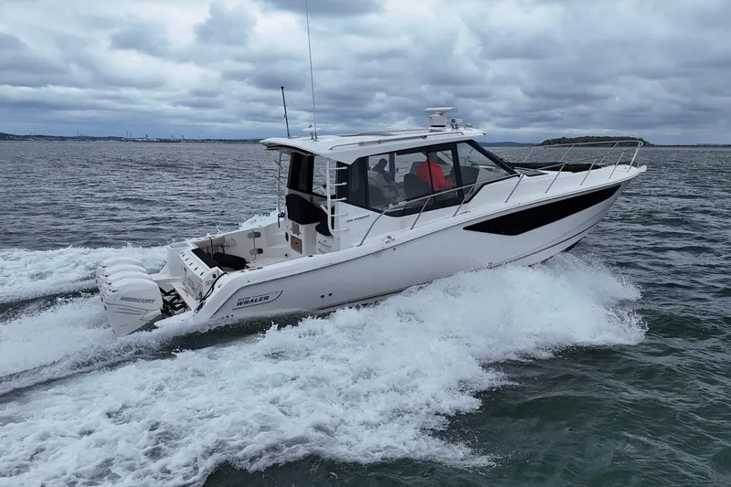 Slide: The Image of 2021 Boston Whaler 405 Conquest cruising on open water under cloudy skies. - 8