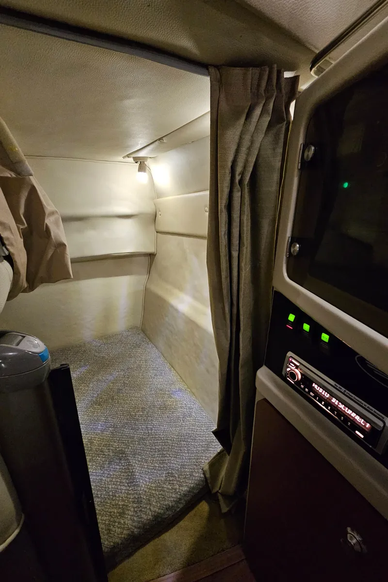 Slide: The Image of 2003 Chaparral 260 Signature Cruiser cabin interior with cozy sleeping area and control panel. - 9