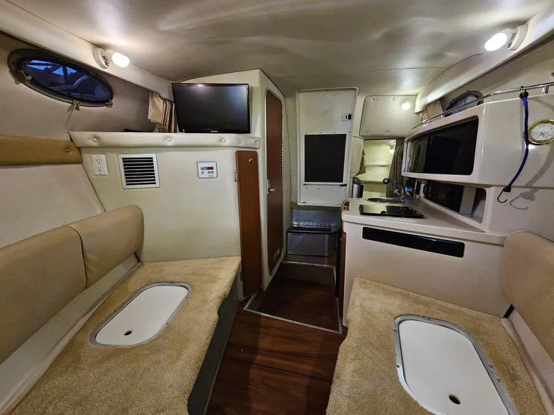 Slide: The Image of Interior of 2003 Chaparral 260 Signature Cruiser with seating, kitchenette, and TV. - 5