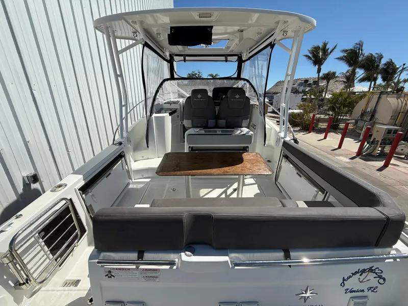 Slide: The Image of 2020 Jeanneau Leader 9.0 WA boat with spacious seating and table, docked outdoors. - 31