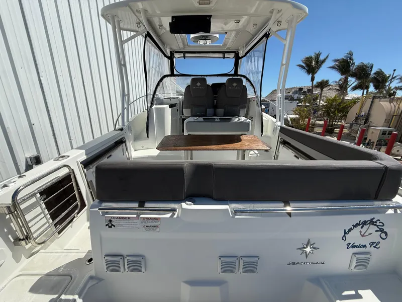 Slide: The Image of 2020 Jeanneau Leader 9.0 WA boat with seating and table, docked outdoors. - 32