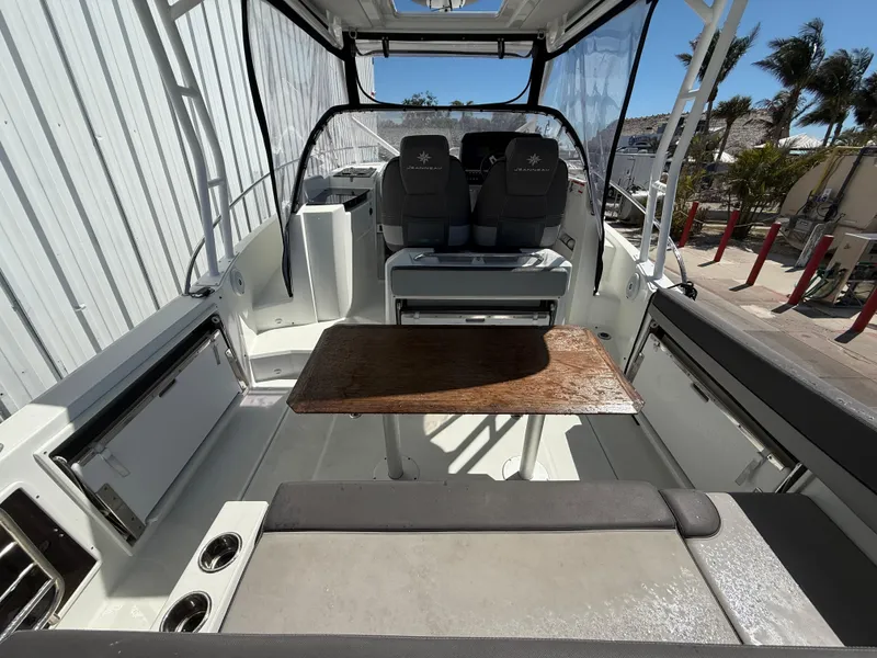 Slide: The Image of 2020 Jeanneau Leader 9.0 WA boat interior with seating and table, dockside view. - 33