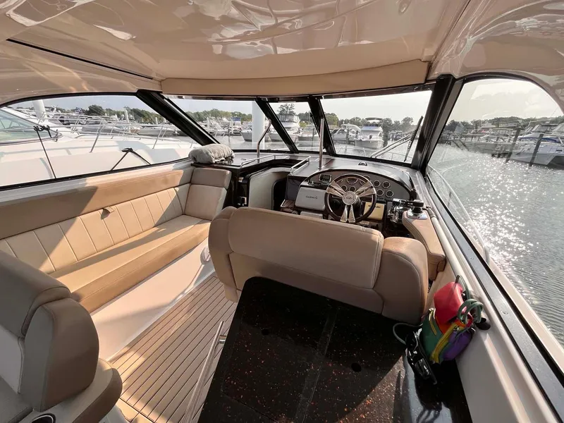 Slide: The Image of Interior of a 2014 Regal 35 Sport Coupe yacht with beige seating and helm. - 20