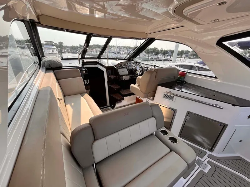 Slide: The Image of Interior of 2014 Regal 35 Sport Coupe yacht with beige seating and modern dashboard. - 21