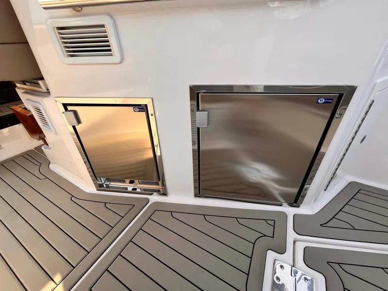 Slide: The Image of 2014 Regal 35 Sport Coupe boat deck with stainless steel storage compartments. - 24
