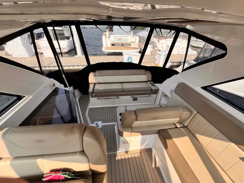 Slide: The Image of Interior of 2014 Regal 35 Sport Coupe yacht with beige seating and waterfront view. - 26