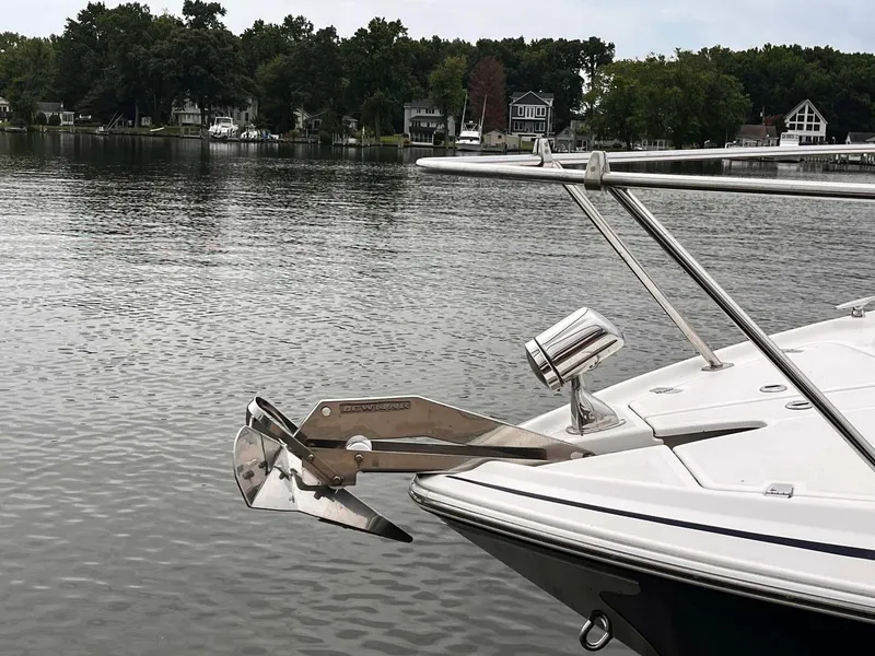Slide: The Image of 2014 Regal 35 Sport Coupe anchored on a serene lake with lush tree-lined shore. - 5
