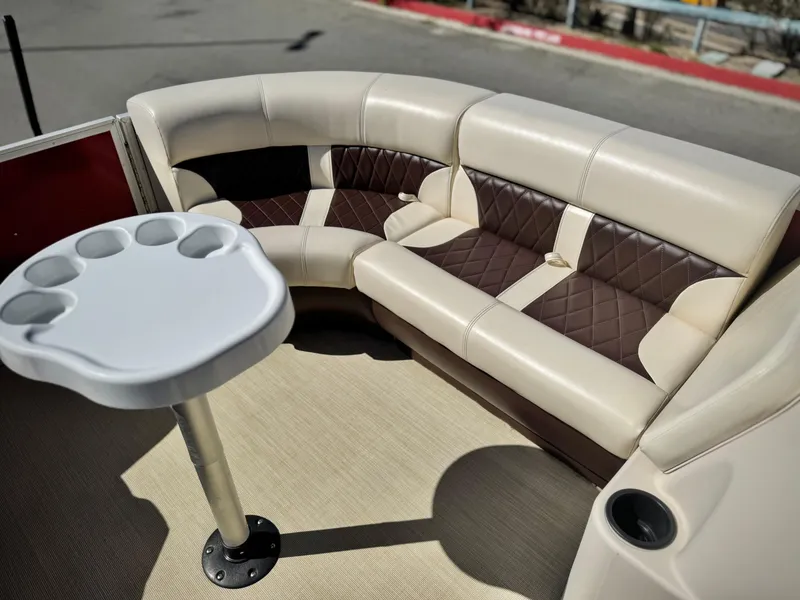 Slide: The Image of 2023 Lexington 321 CRUISE boat interior with beige and brown seating, cup holder table. - 13