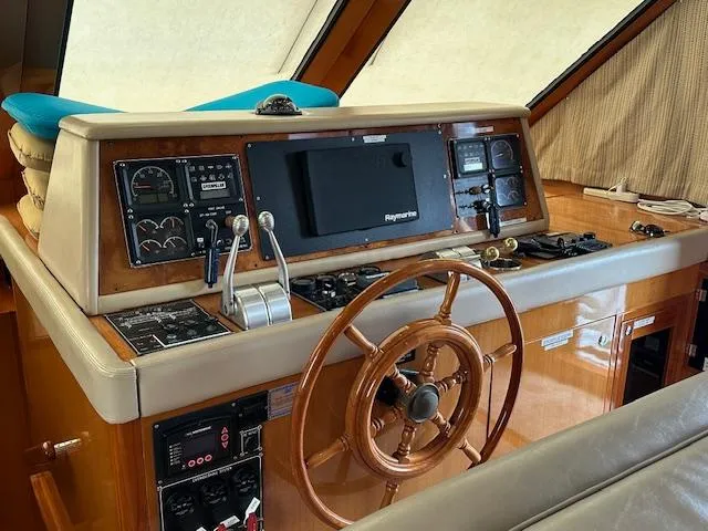 Slide: The Image of Helm of 2000 Jefferson Marquessa 60 MY yacht with wooden steering wheel and navigation controls. - 11