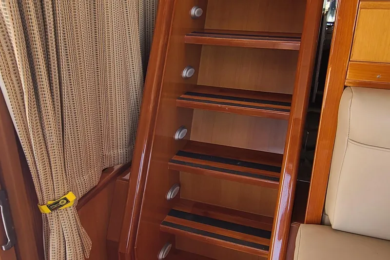 Slide: The Image of Wooden staircase inside 2000 Jefferson Marquessa 60 MY yacht, with beige curtains and seating. - 13