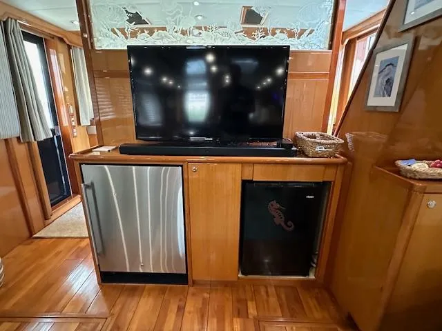 Slide: The Image of Interior of 2000 Jefferson Marquessa 60 MY yacht with TV, mini fridge, and wood paneling. - 6