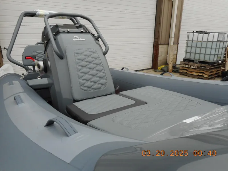 Slide: The Image of 2025 Highfield Sport 390 boat interior with gray seating and console. - 2