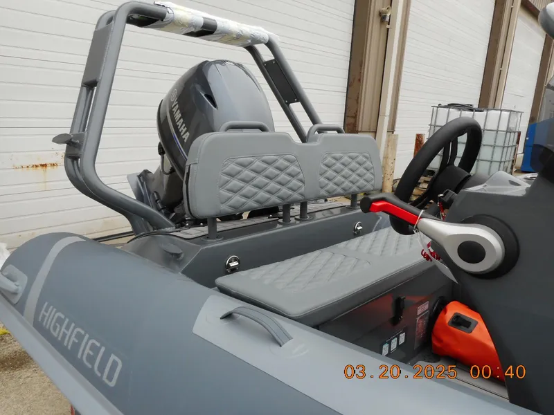 Slide: The Image of 2025 Highfield Sport 390 boat interior with Yamaha engine, gray seating, and steering wheel. - 3