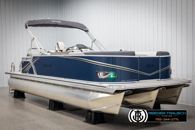 Slide: The Image of 2025 Avalon LSZ Entertainer pontoon boat in showroom, blue and silver design. - 2