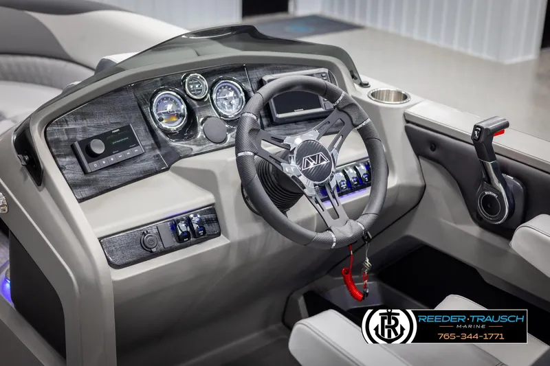 Slide: The Image of 2025 Avalon LSZ Entertainer boat dashboard with steering wheel and controls, featuring modern design elements. - 25