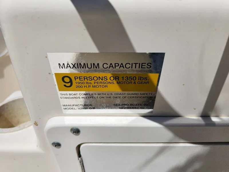 Slide: The Image of 2002 Sea Pro SV2100CC Bay Boat capacity label, 9 persons or 1350 lbs, 200 HP motor. - 44