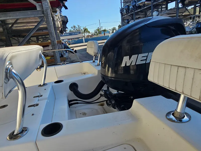 Slide: The Image of Boston Whaler 210 Montauk 2012 boat interior with Mercury engine in storage facility. - 16