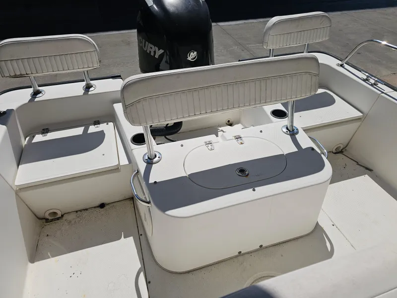 Slide: The Image of 2012 Boston Whaler 210 Montauk boat interior with seating and Mercury engine. - 32